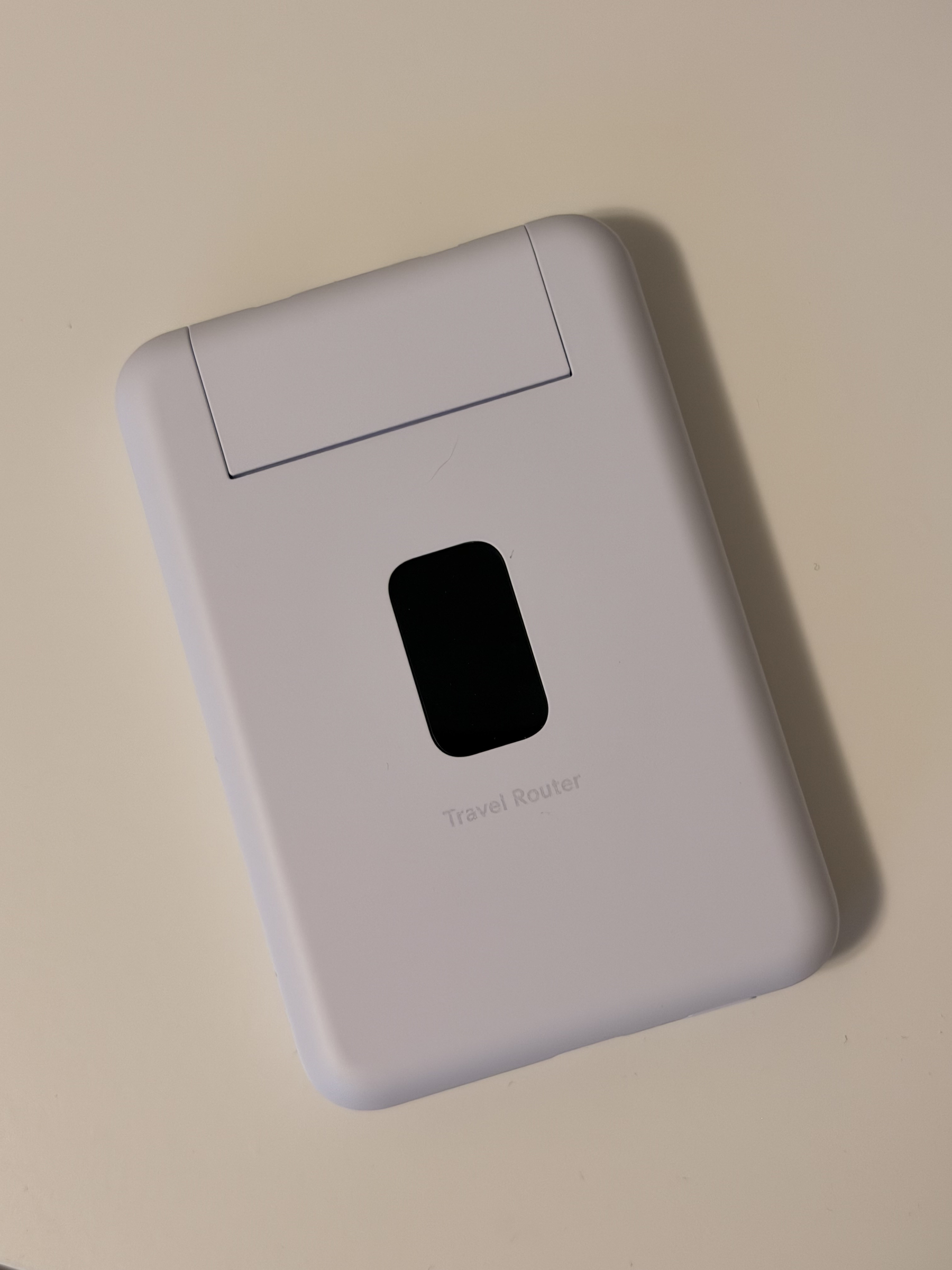 The UniFi Travel Router, a small white device with a dark display